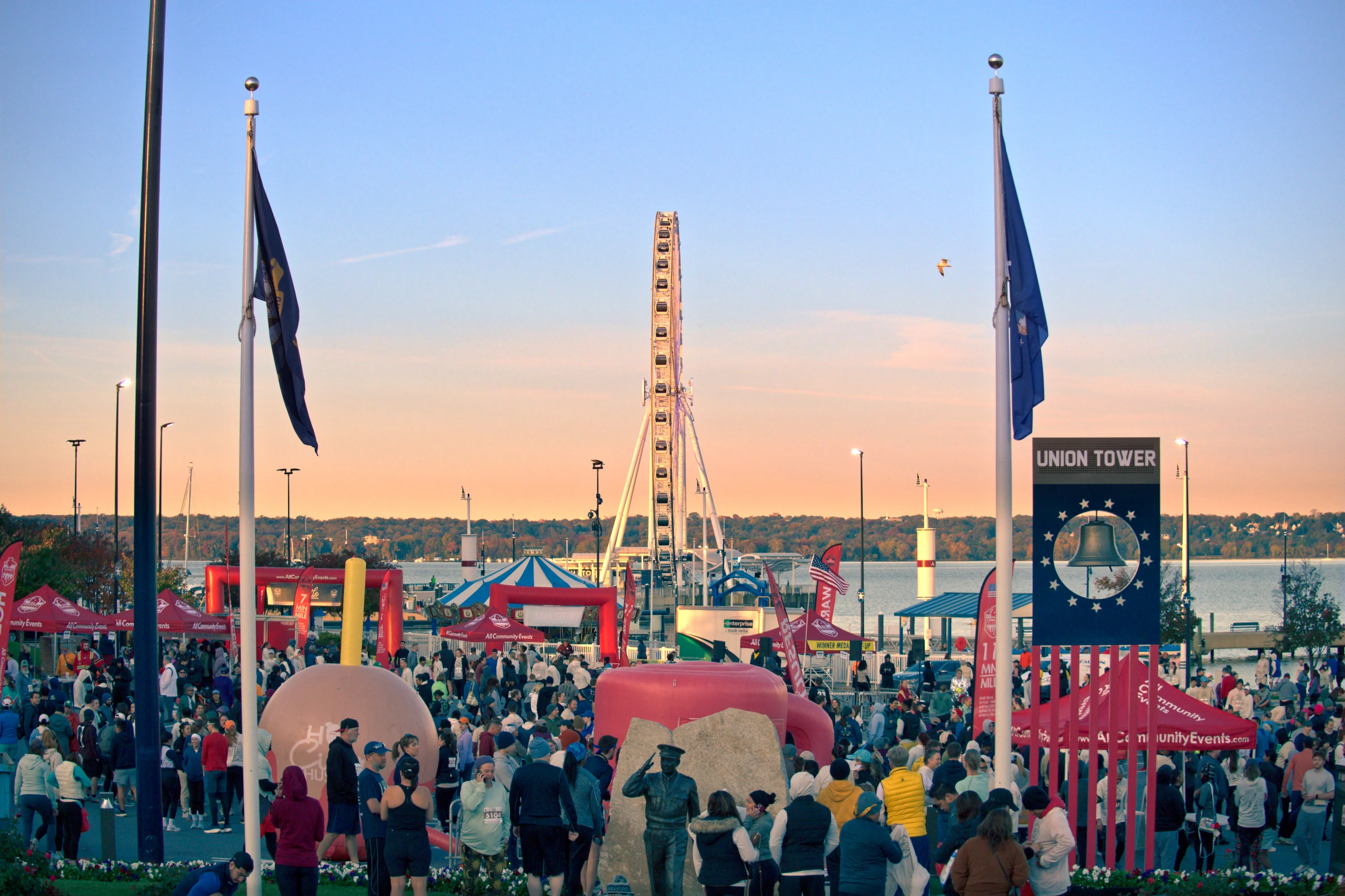 Large crowd gathered for an outdoor community event at National Harbor with the Capital Wheel in the background.