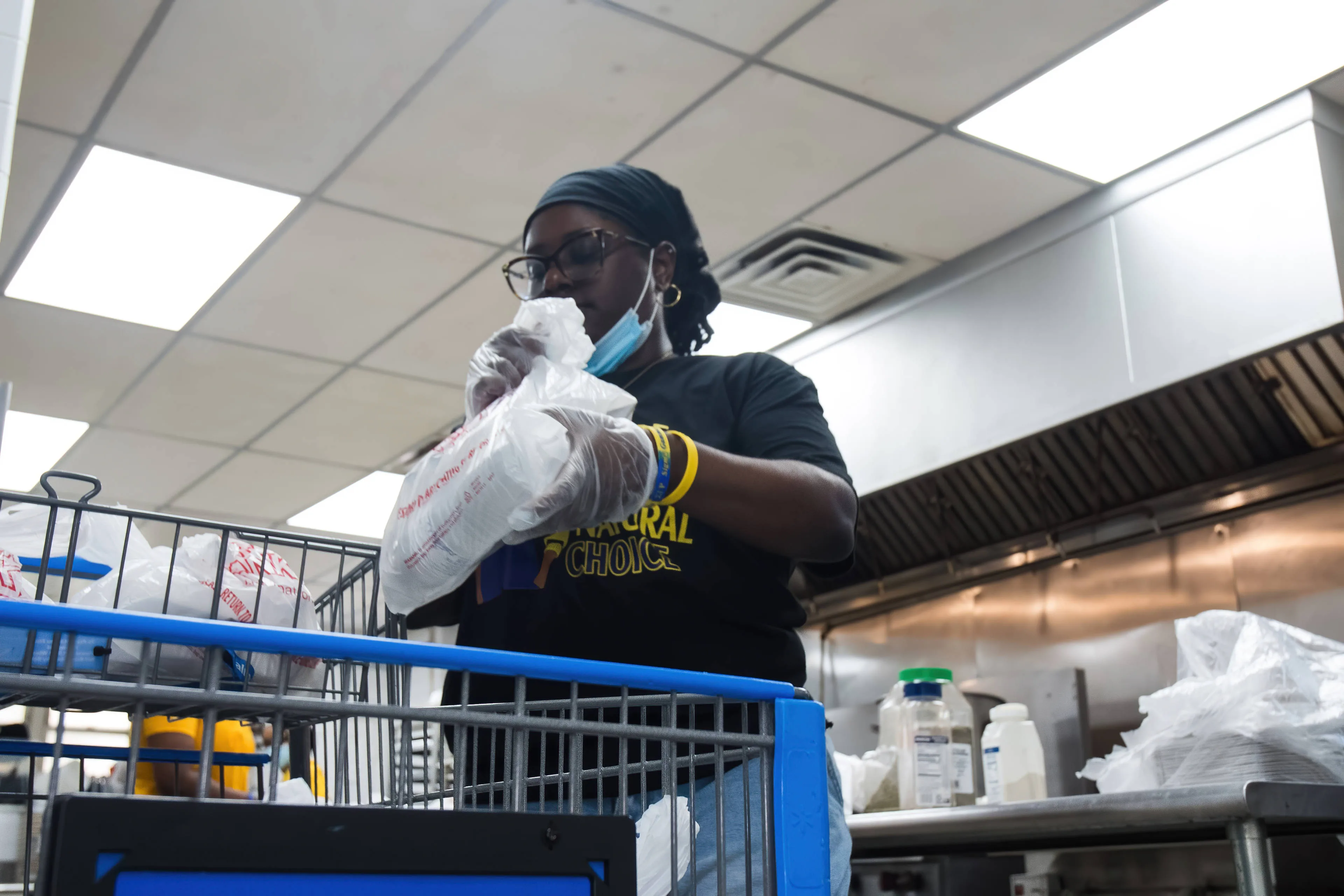 Volunteer packing prepared meals as part of a community outreach project documented by Mighty Lux Media.